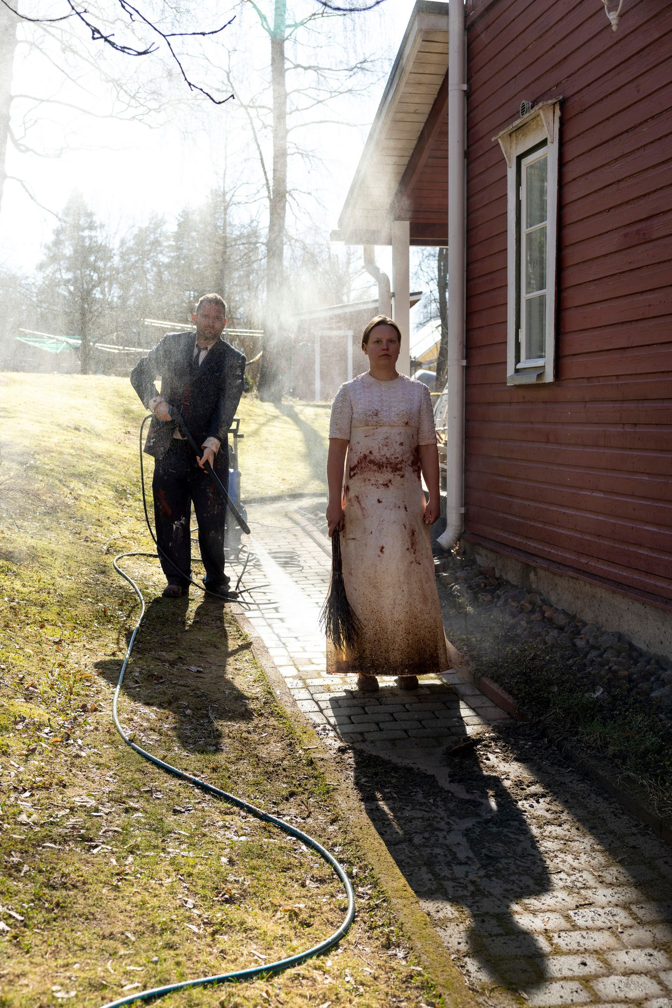 Mammu and Pasi standing in their wedding attire with neutral expressions staring at the camera.