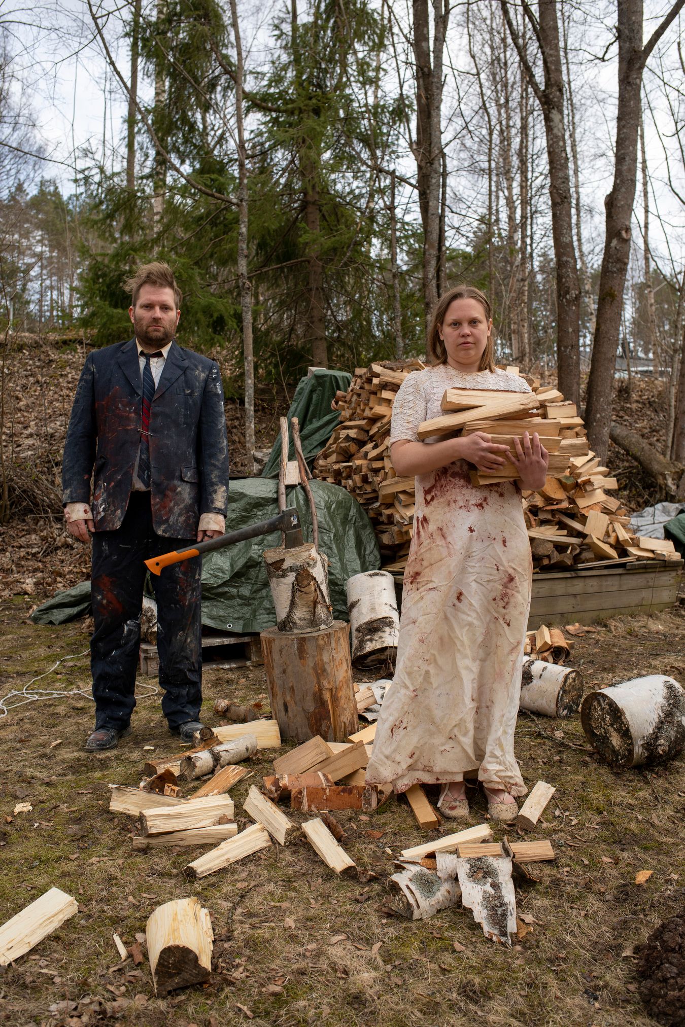 Mammu and Pasi standing in their wedding attire with neutral expressions staring at the camera.