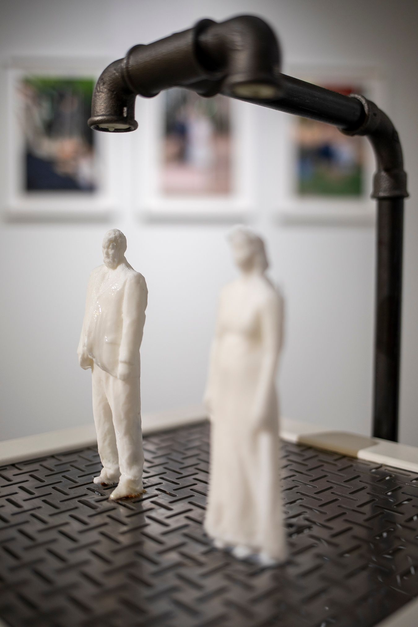 A close-up picture of soap figures of Mammu and Pasi standing under water faucets.