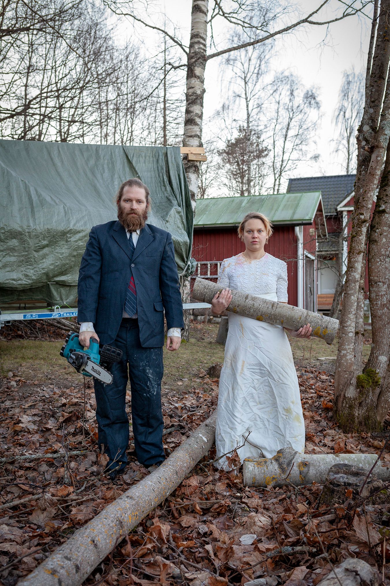 Mammu and Pasi standing in their wedding attire with neutral expressions staring at the camera.