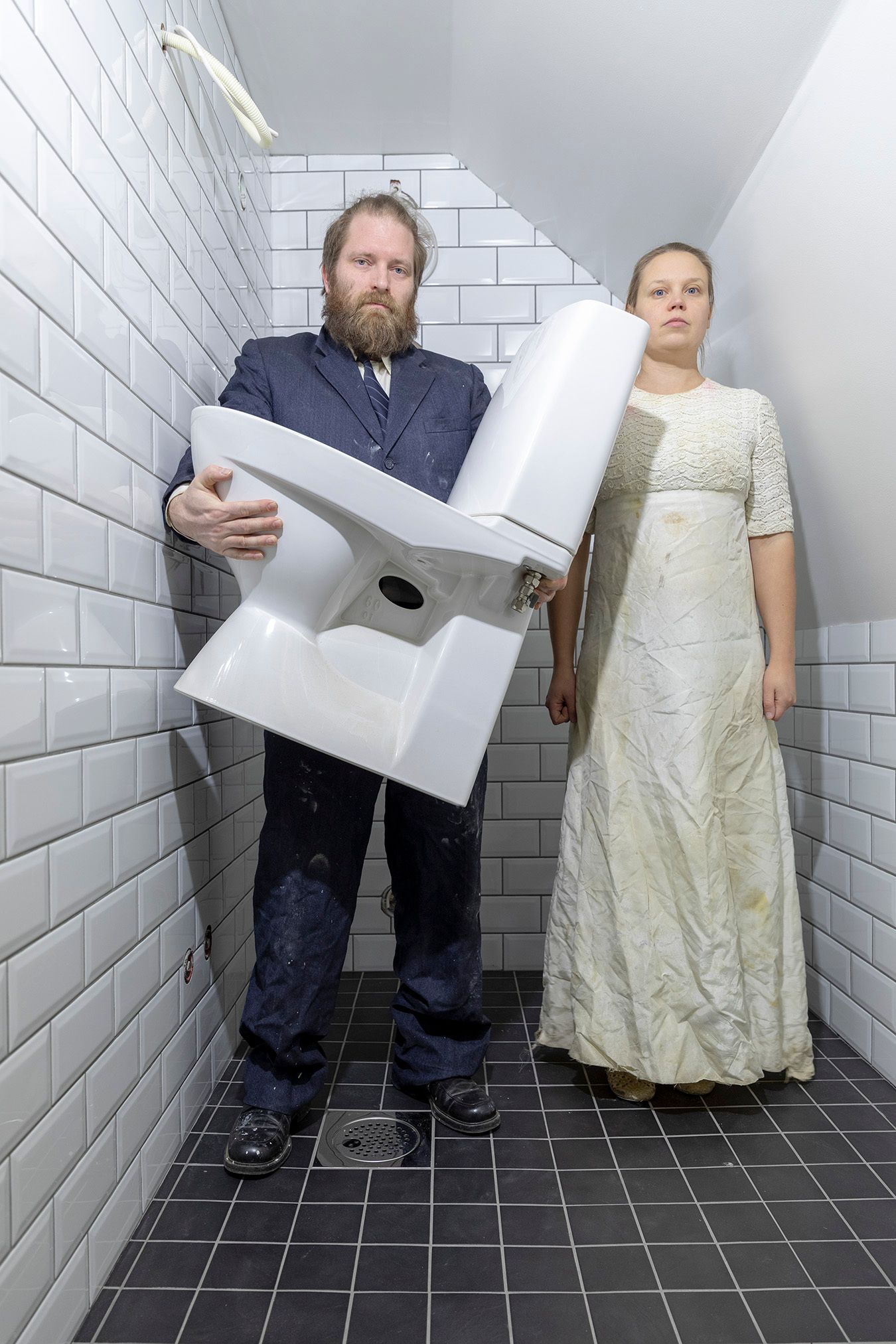 Mammu and Pasi standing in their wedding attire with neutral expressions staring at the camera.