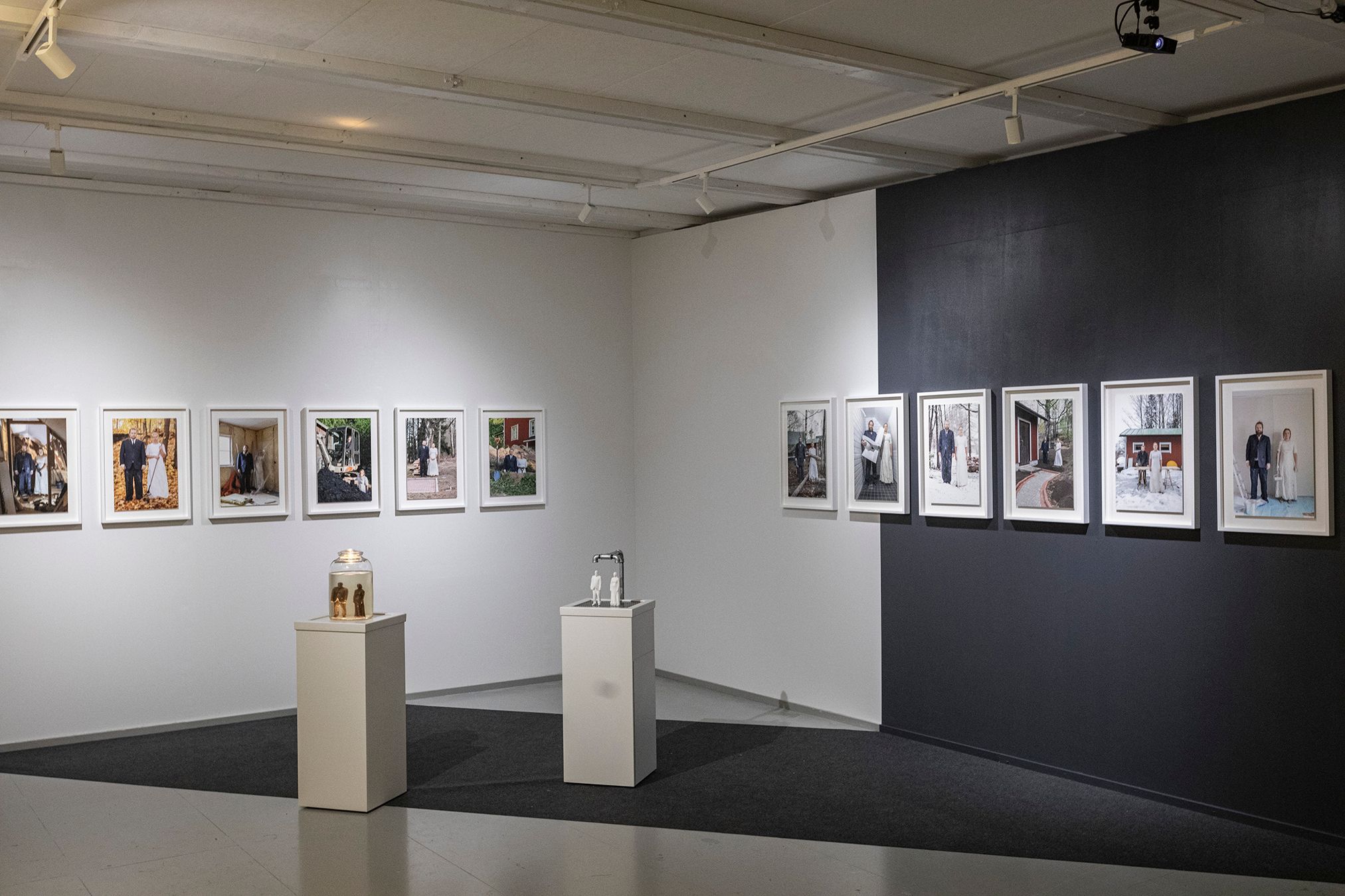 An overview picture from the exhibition with two sculptural elements and photographs on the walls.