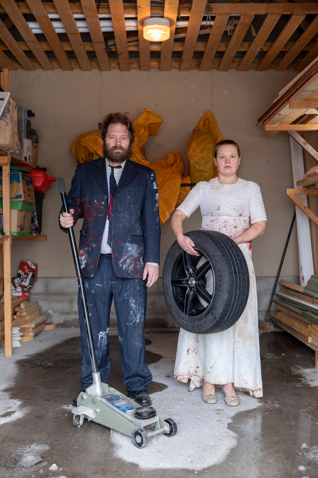 Mammu and Pasi standing in their wedding attire with neutral expressions staring at the camera.