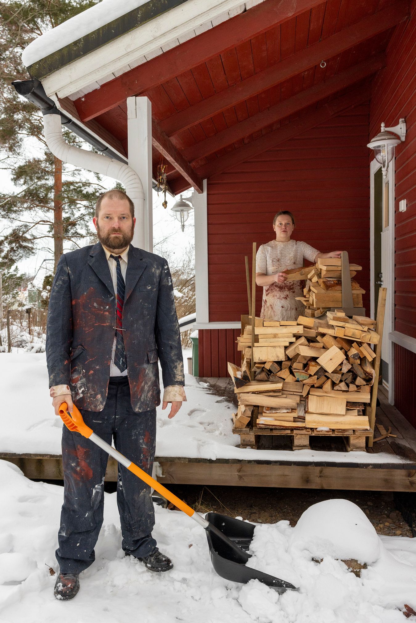 Mammu and Pasi standing in their wedding attire with neutral expressions staring at the camera.