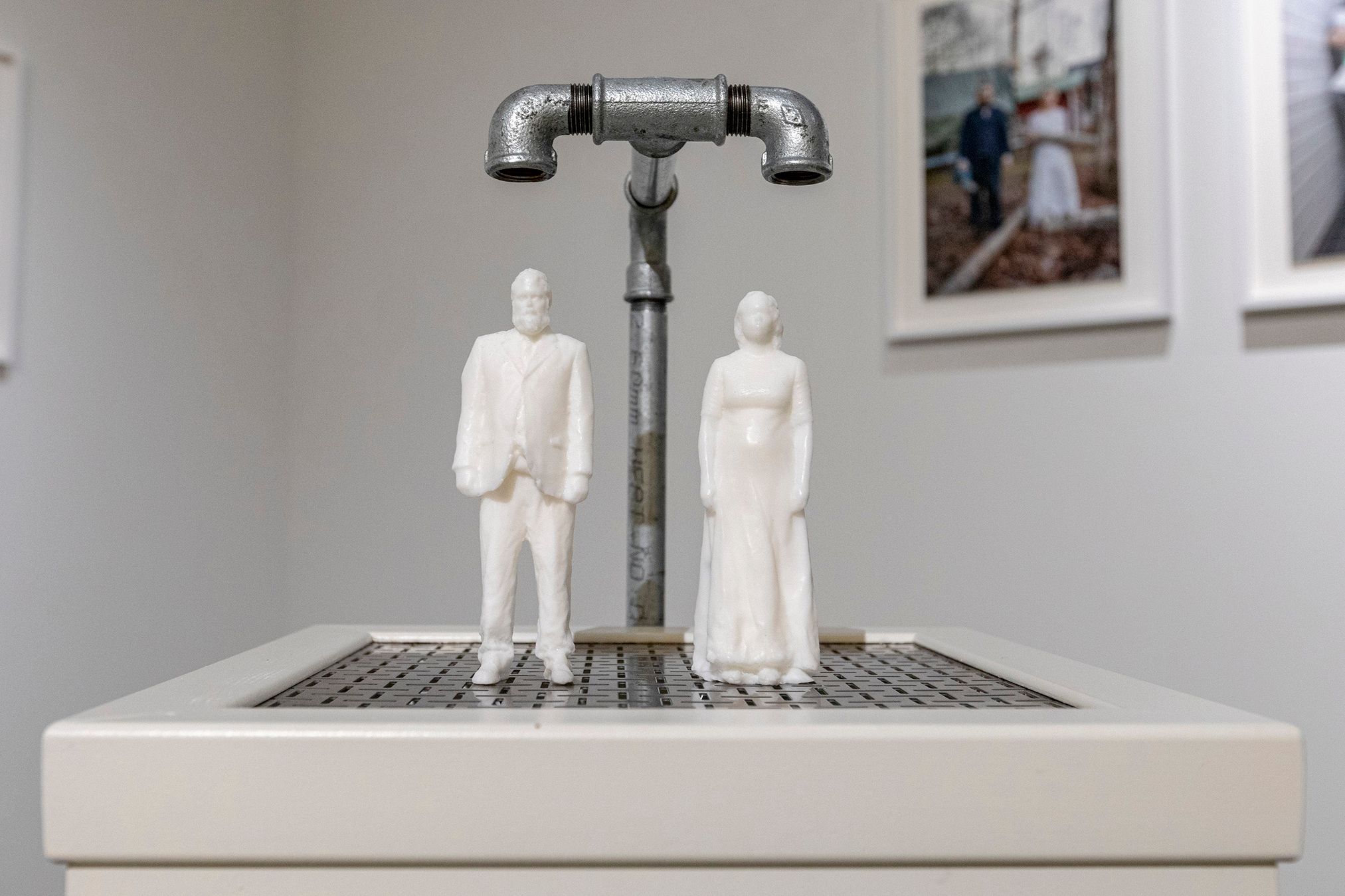 Soap figures of Mammu and Pasi standing under their own water faucets.