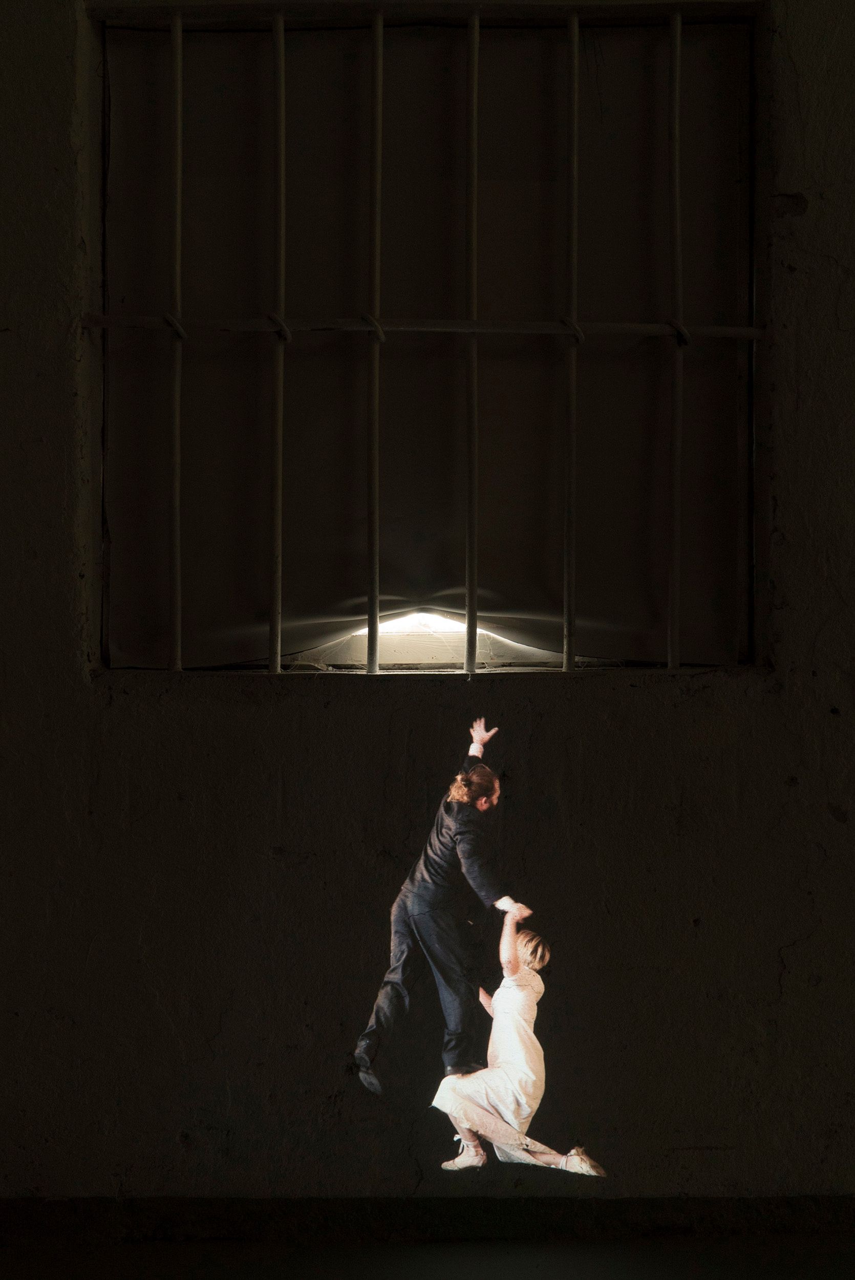 Video projection of small-scale Mammu and Pasi trying to jump to reach a windowsill from the ground.